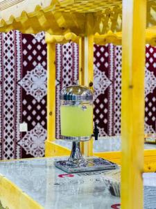una bebida verde en un tazón de cristal sobre una mesa en DESRT STARS lUXURY CAMP, en Wadi Rum