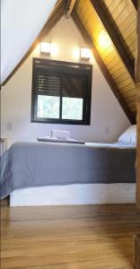 ein Schlafzimmer mit einem großen Bett im Dachgeschoss in der Unterkunft Cabana Barragem do Salto - 15 min de Canela in São Francisco de Paula