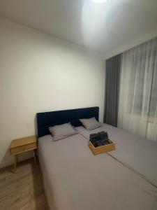 a bedroom with a bed with a box on it at Apartament Noniewicza 95 in Suwałki