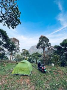 una tienda y una motocicleta estacionadas en un campo en Tent Stay Paithalvillage, en Jāmb