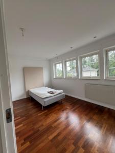 a bedroom with a bed in a room with windows at villa lina hage södertälje in Södertälje