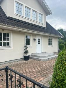 a white house with a brick driveway at villa lina hage södertälje in Södertälje