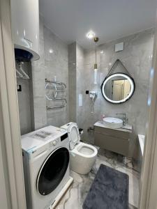 ein Badezimmer mit Waschmaschine und Waschbecken in der Unterkunft Стильная квартира в ЖК Абай 2 in Kökschetau