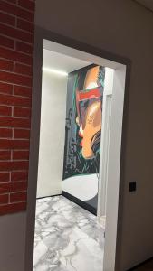 ein Gemälde einer Frau an einer Wand in einem Flur in der Unterkunft Стильная квартира в ЖК Абай 2 in Kökschetau