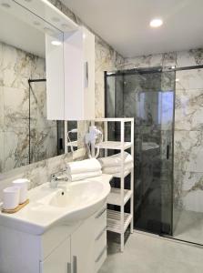 a white bathroom with a sink and a shower at Schneider Appartements Steinhude in Niederdorla