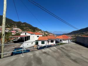 ein Haus mit einem auf einem Parkplatz geparkten Auto in der Unterkunft Sea View Madeira Machico 1 Bedrooms Terrace Villa in Ribeira Seca