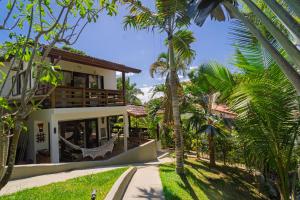 a house with palm trees in front of it at Casas Divino in Cayru