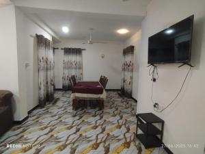 a living room with a table and a flat screen tv at Randuli Holiday Homes in Anuradhapura +13 photos