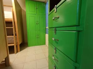 a green kitchen with two green doors in a room at Jardin 85 Hostel in Morelia