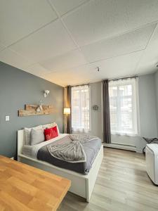 a bedroom with a bed with red pillows on it at Urban Loft, St-Joseph St in Quebec City