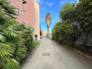 an empty street with a palm tree and a building at Casa Esemes in Giarre