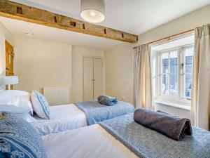 a bedroom with two beds and a window at 4 Bed in Sedbergh SZ595 in Milnthorpe