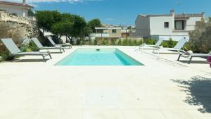 a swimming pool with lounge chairs and a house at Dimora Zenieri – Terrazze & Piscina in Casarano