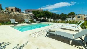 a swimming pool with two lounge chairs and a table at Dimora Zenieri – Terrazze & Piscina in Casarano