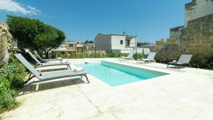 a swimming pool with two lounge chairs next to a building at Dimora Zenieri – Terrazze & Piscina in Casarano
