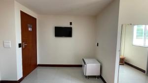 a room with a door and a television on the wall at Caminho de Itacoatiara in Niterói