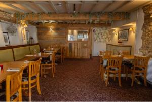 a restaurant with wooden tables and chairs in a room at Sturdy`s Castle - Historic Coaching Inn near Blenheim Palace, Oxfordshire in Woodstock