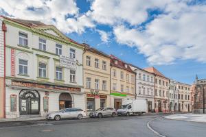a street with cars parked in front of buildings at Obrovský byt na Velkém náměstí, WiFi zdarma in Hradec Králové