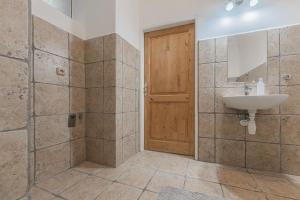 a bathroom with a sink and a wooden door at Obrovský byt na Velkém náměstí, WiFi zdarma in Hradec Králové +45 photos