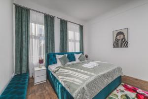 a bedroom with a blue bed and a window at Obrovský byt na Velkém náměstí, WiFi zdarma in Hradec Králové