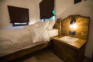 a bedroom with a bed with a wooden headboard at Etno Park Avlija Glušci 
