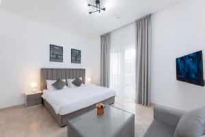迪拜Comfort Ensuite with Balcony的一间带床和沙发的白色卧室 更多9张照片