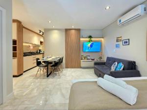a living room with a couch and a dining room at Studio Novo no Centro para 4 pessoas in Foz do Iguaçu