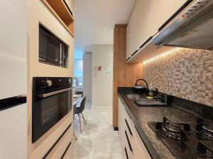 a kitchen with a sink and a stove at Studio Novo no Centro para 4 pessoas in Foz do Iguaçu