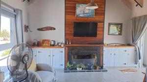 a living room with a fireplace and a flat screen tv at Die Fonteintjie in Stompneusbaai +3 photos