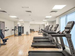 a gym with a row of treadmills and machines at F1 - A Place to Stay 1BR Waters Edge Yas Island - Theme Parks in Abu Dhabi