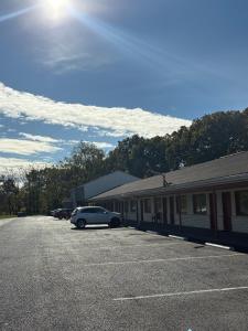 Un coche aparcado en un aparcamiento junto a un edificio. en Hollywood Motel, en Middletown