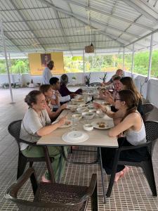 Un grupo de personas sentadas en una mesa comiendo en VILLA MANTRAA, en Varkala