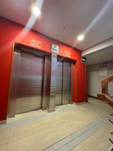 two elevators in a building with red walls at Apartamento en Alpedrete in Alpedrete +1 photo