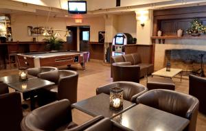a restaurant with tables and chairs and a pool table at Armon Plaza Montreal Airport in Montréal
