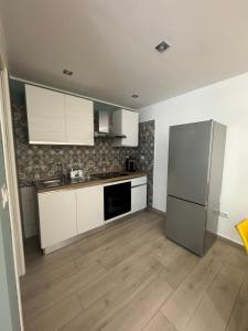 a kitchen with white cabinets and a refrigerator at AparthouseRisorgimento MISENO in Frattamaggiore