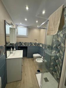 a bathroom with a toilet and a sink and a shower at AparthouseRisorgimento MISENO in Frattamaggiore
