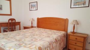 a bedroom with a bed and a dresser and two lamps at Clube Meia Praia in Lagos