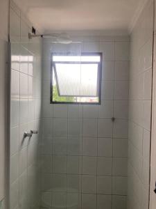 um banheiro com chuveiro e janela em Smart Flat Apart em Mogi das Cruzes
