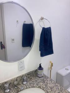 a bathroom with a sink with a mirror and blue towels at Smart Flat Apart in Mogi das Cruzes +18 photos