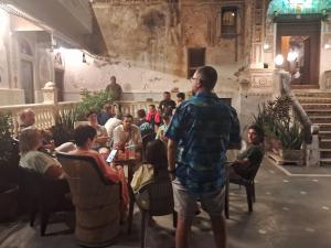 a man standing in a room with a crowd of people at Hotel Radhika Haveli, Mandawa in Mandāwa