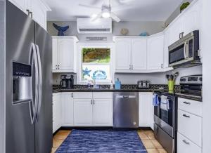 Caret Bay EstateにあるPrivate Villa with Pool and Incredible Sea Viewsの白いキャビネットとステンレス製の冷蔵庫を備えたキッチン