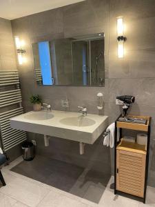 a bathroom with a sink and a mirror at Hotel Europe Brig in Brig +87 photos