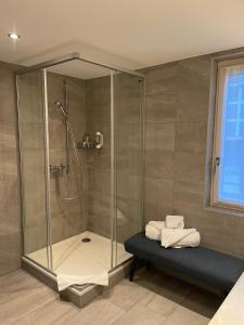 a shower stall with a bench in a bathroom at Hotel Europe Brig in Brig