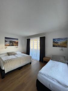 a bedroom with two beds and a window at Hotel Europe Brig in Brig