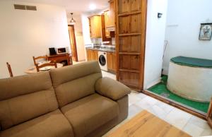 a living room with a couch and a kitchen at El Refugio de la Judería in Córdoba