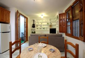 a kitchen and living room with a table and a couch at El Refugio de la Judería in Córdoba