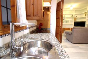 a kitchen counter with a sink and a couch at El Refugio de la Judería in Córdoba +24 photos
