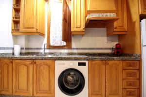 a kitchen with a washing machine under the counter at El Refugio de la Judería in Córdoba