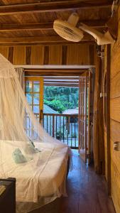 a bedroom with a bed with a mosquito net at El Almendrón Beach Hostel in Santa Marta