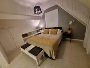 a bedroom with a bed and a chair in it at Vila de Charme Suítes in Campos do Jordão